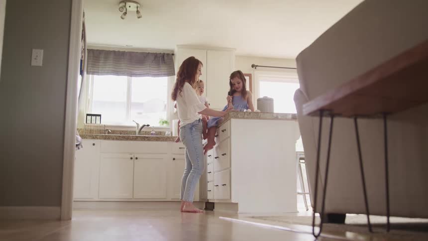 Mother and her children talking in the kitchen at home