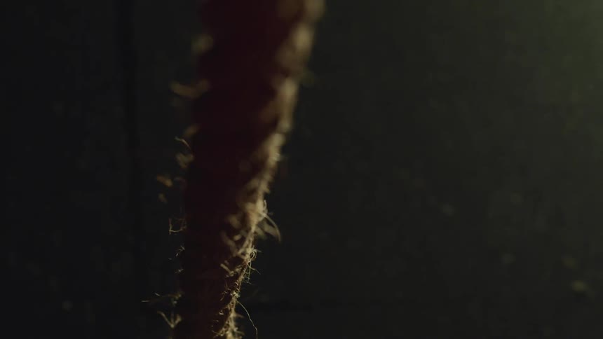 Close up of a tense rope against a black background