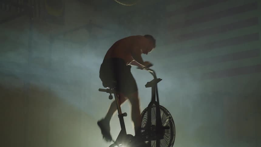A man is pedaling on the exercise bike