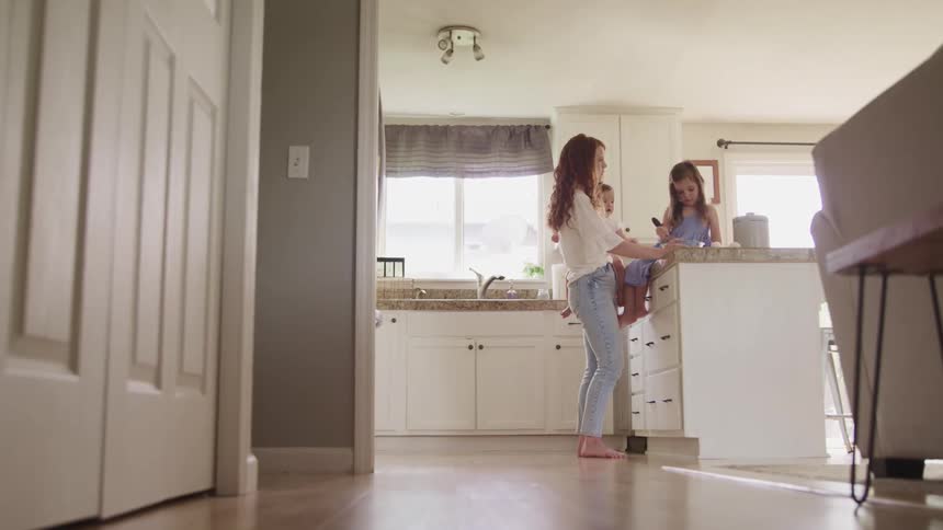 Mother play with her daughter in the kitchen at home