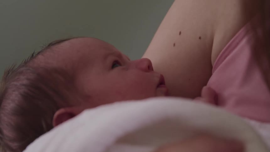 Mother holding a newborn baby in her arms at home