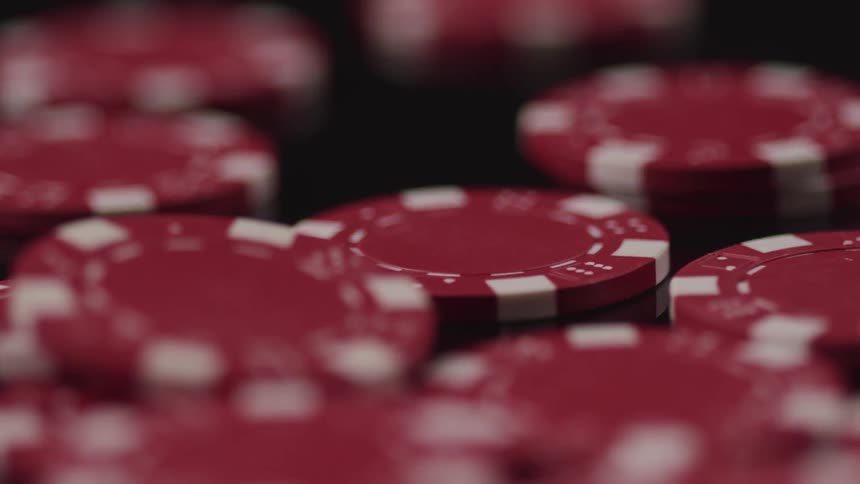 Red and white poker chips lay in stacks on surface