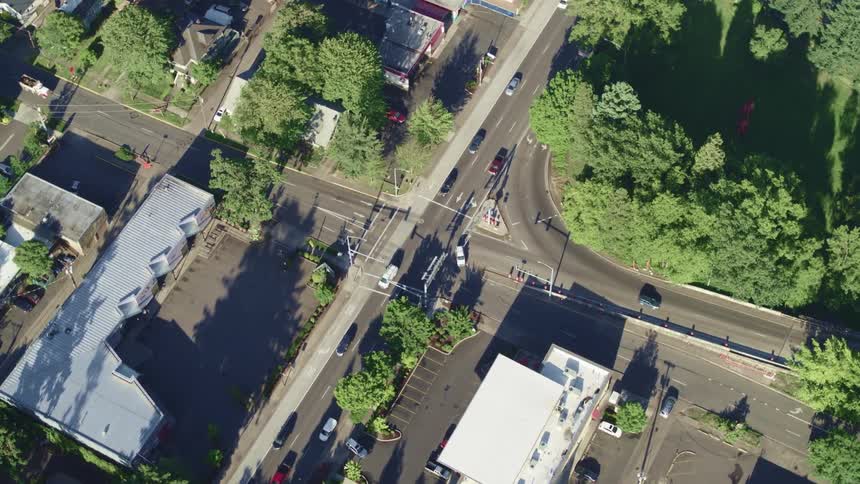 Traffic passes through intersection bordered by empty field