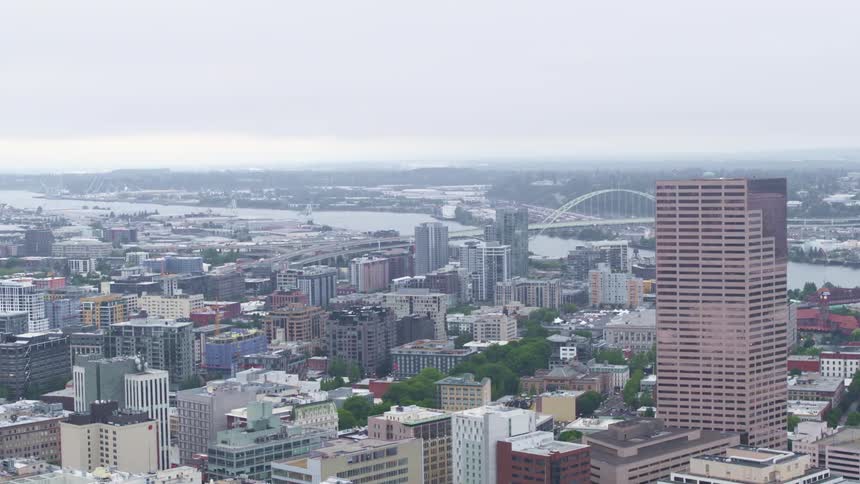 A wide river separates a downtown city from less dense neighborhoods