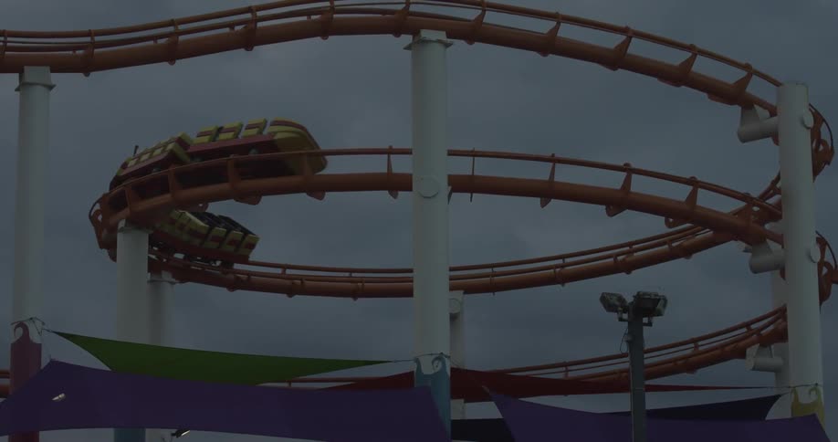 A roller coaster full of people is going over some tracks