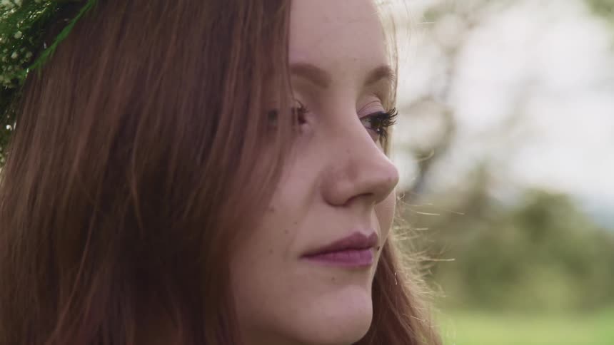 A side view of a pregnant woman with a flower crown