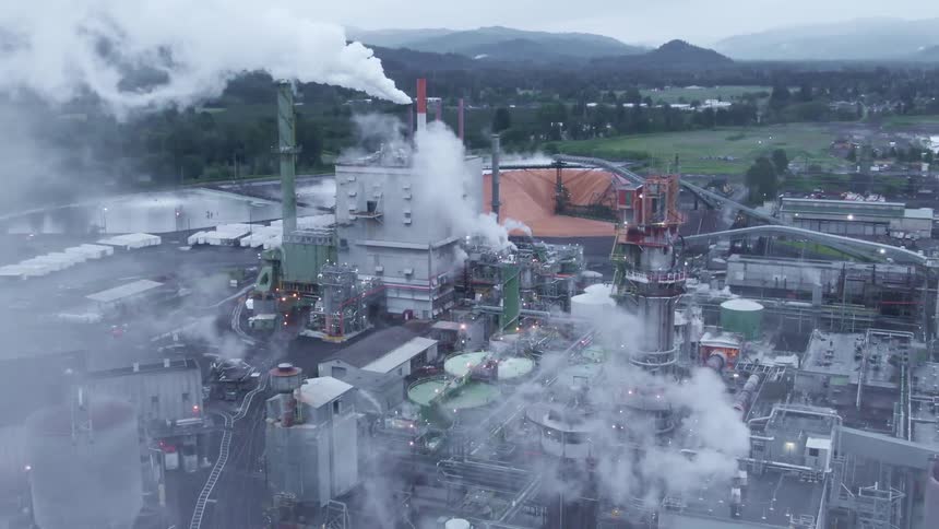 Heavy smoke pours from the factory below