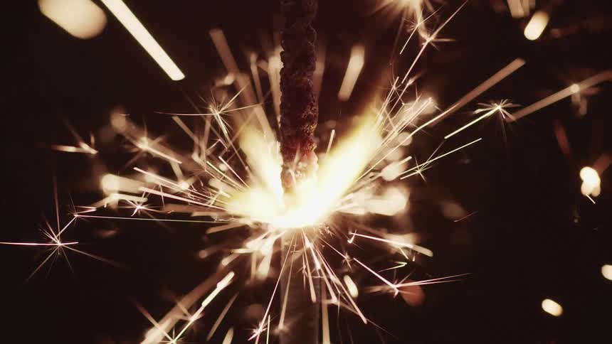 Sparkler firework burns down releasing sparks into night