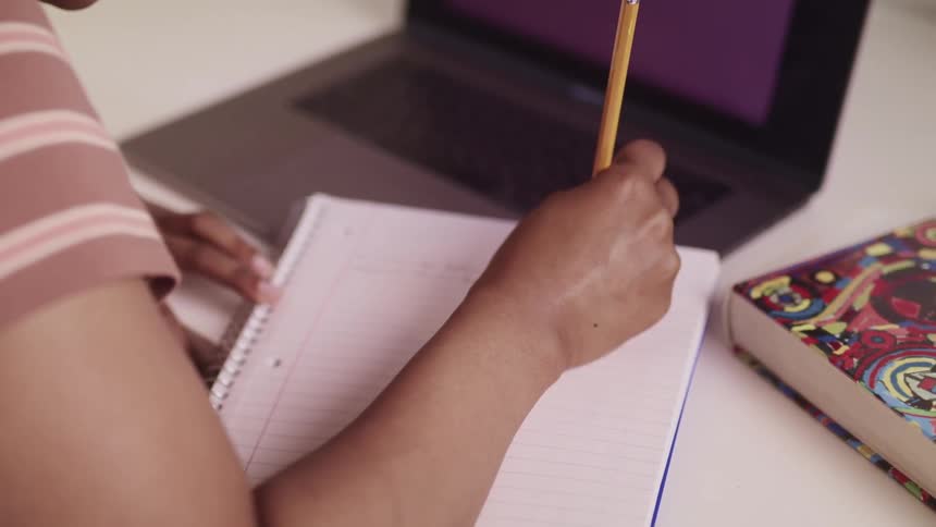 A person is writing in their notebook