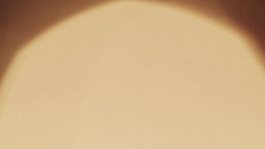 Circular shaped orange tinted light glows and flickers