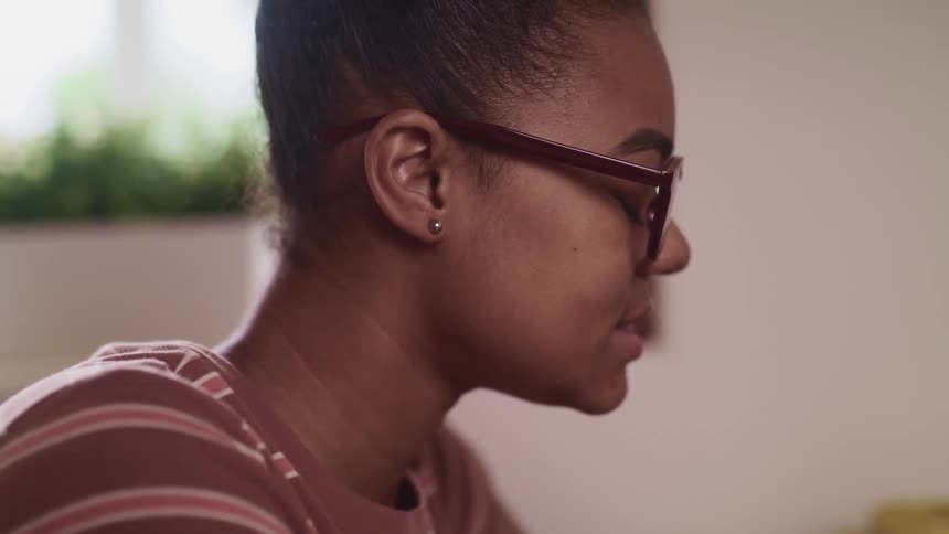 Close up of a womans face profile while smiling wearing glasses