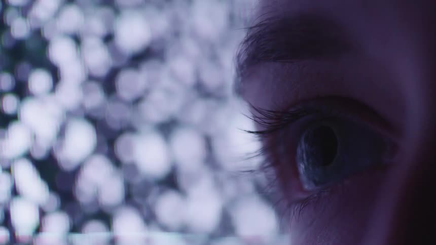 The persons eye blinks in front of the television
