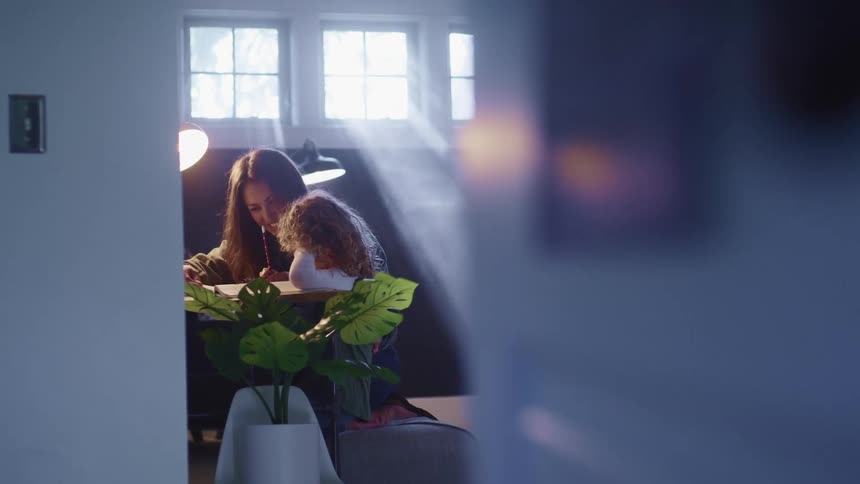 A woman helps a child with some schoolwork