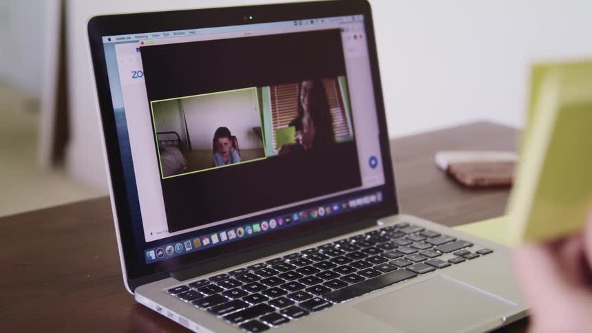 A person is flipping note cards on a video conference