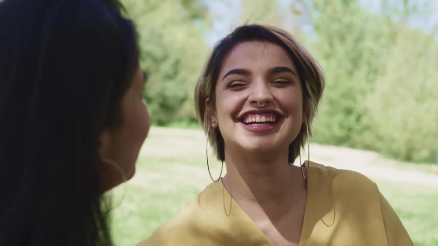 Two women laugh and talk together
