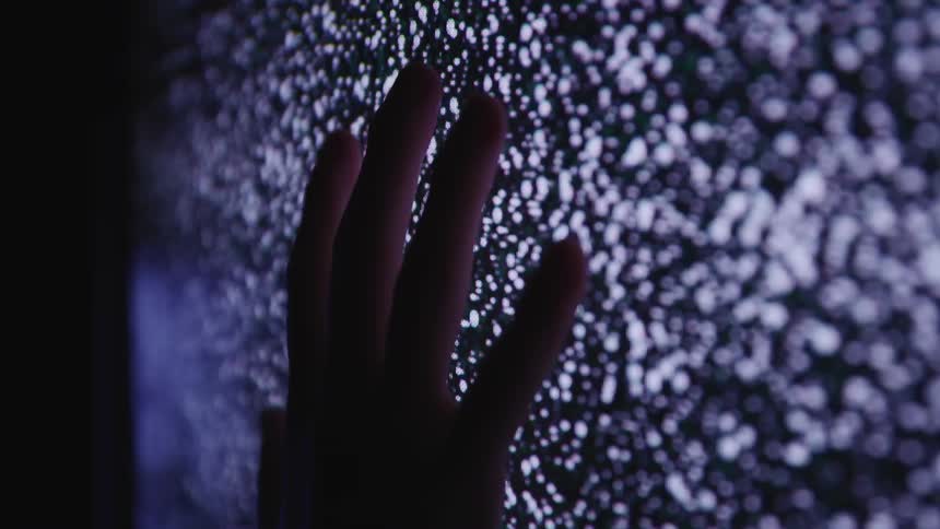 A persons hand on a television screen with statics snow