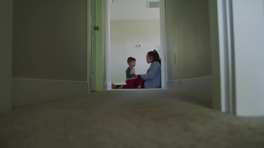 Woman sits with a young boy and talks with him