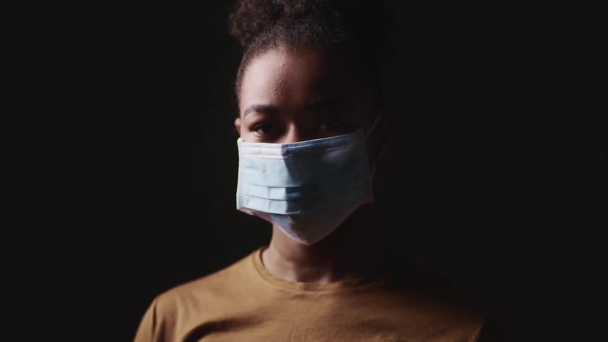 Close up of a young womans face wearing a blue face mask