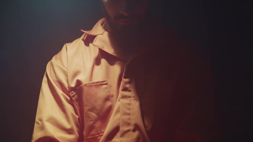 A man sits in a room looking down