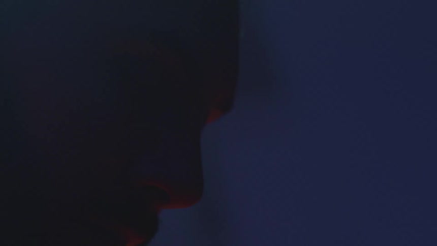 Close up of a mans forehead with eyes closed in a dark room