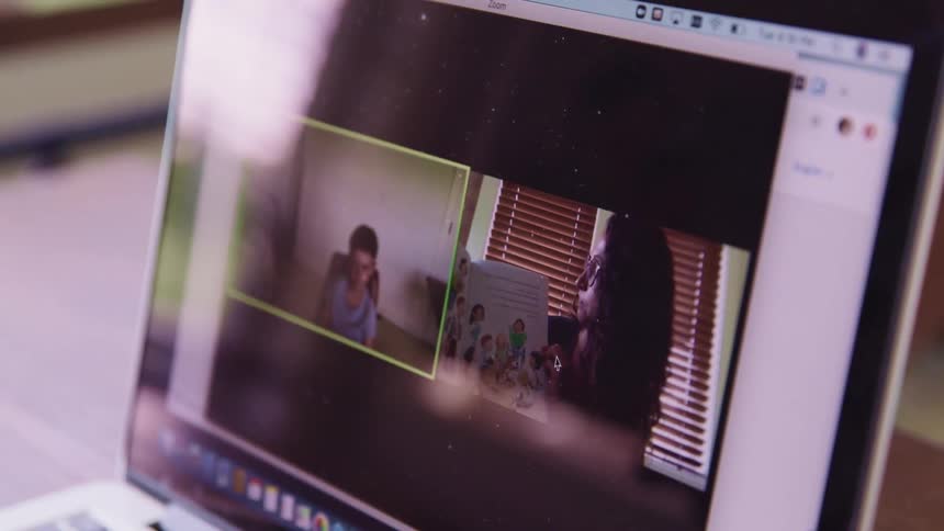 A laptop with a student and teacher doing a online class