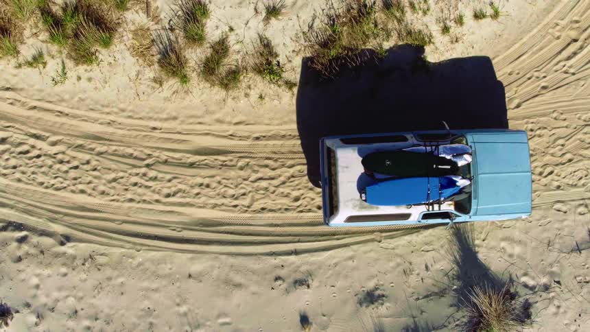 A vehicle stops on the trail in the sand