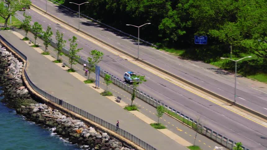 A car is driving on a highway in the spring