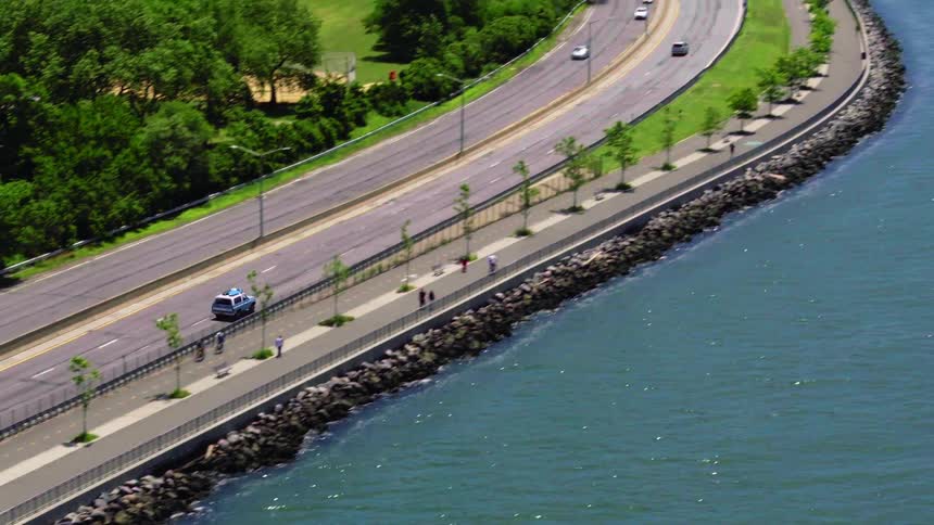 A vehicle traveling with traffic along a freeway next to the ocean