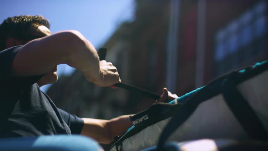 A man ties something on to the roof of his car
