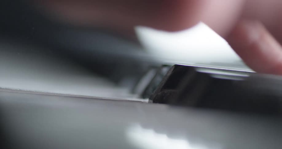 Fingers wipe dust off piano keys