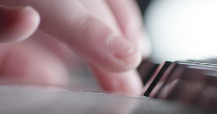 Fingers press piano keys