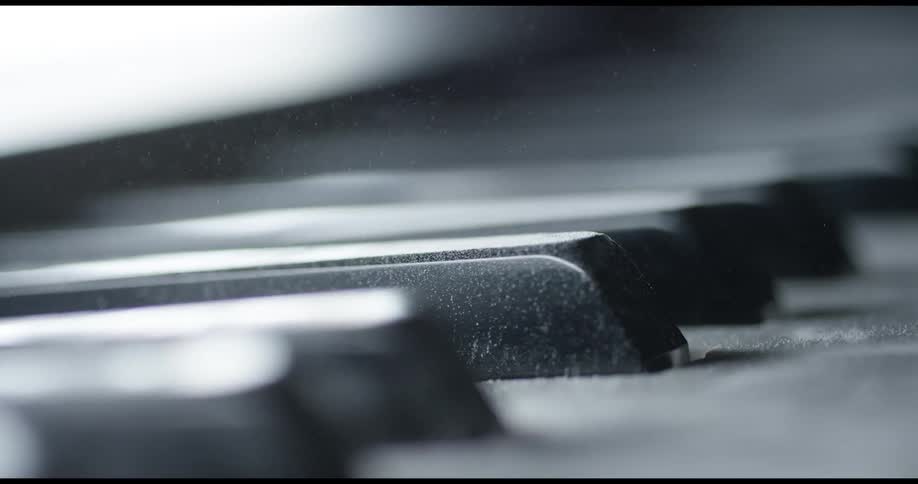 Light is reflecting off keys on a piano