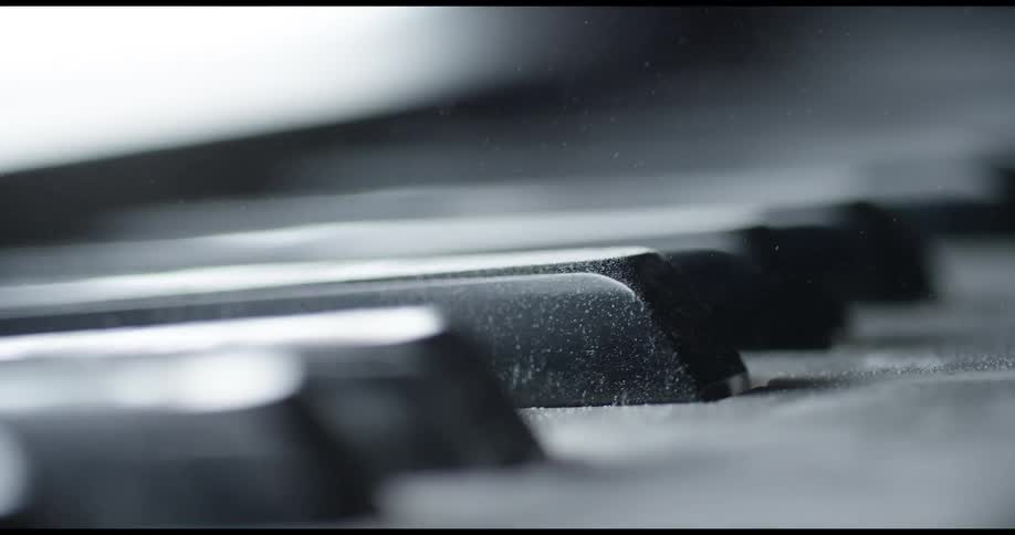 Shadow and light are creeping over keys on a piano