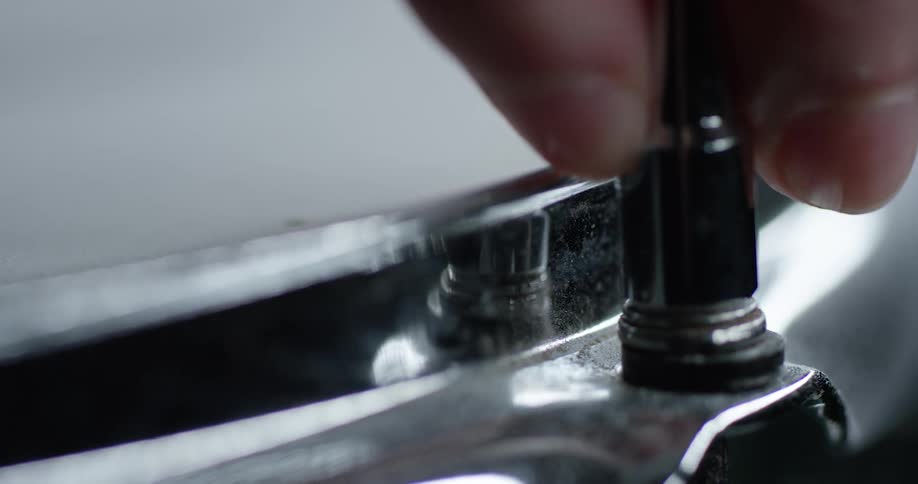 A man puts a ratchet onto a bolt