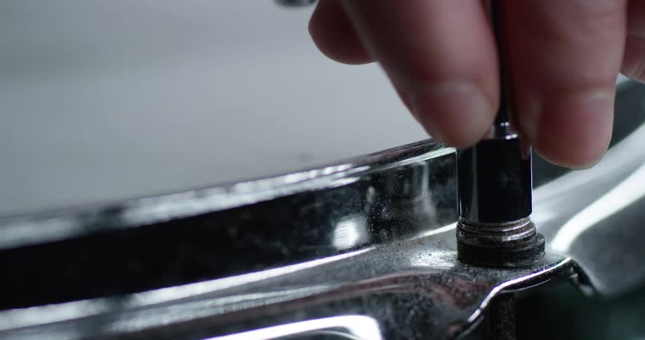 A tool is used to tighten a drumhead