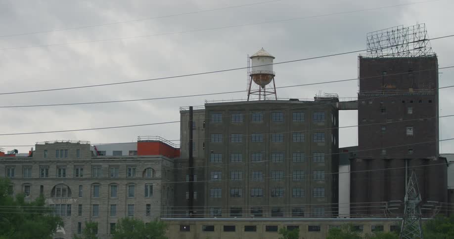 An old water tower sitting on the roof of an urban building