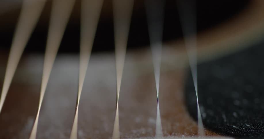 A finger plucks guitar strings