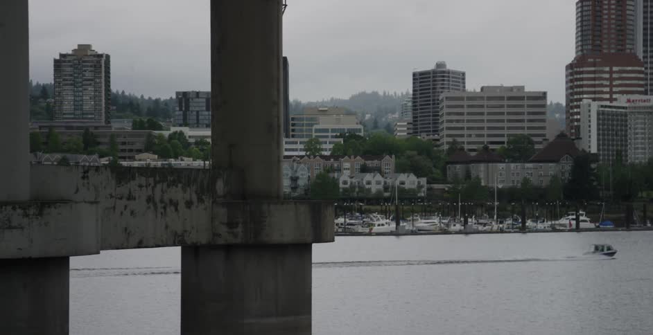 A boat speeds down a body of water with city buildings in the background