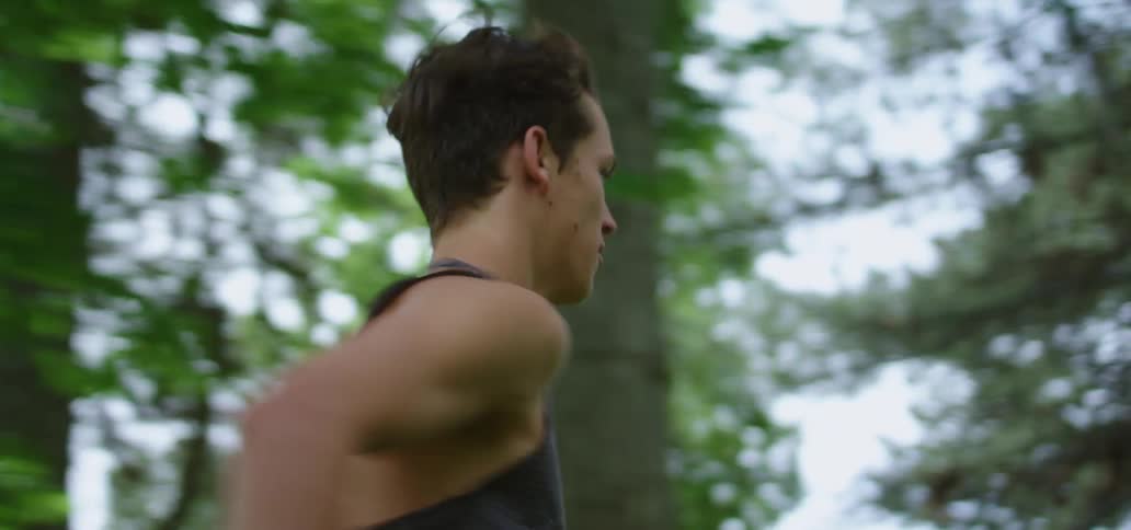 Young man running for exercise through the woods at day