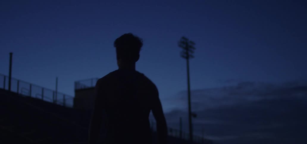 A man is walking outdoors at night