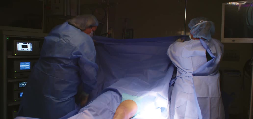 Surgical nurses preparing a patient for knee surgery