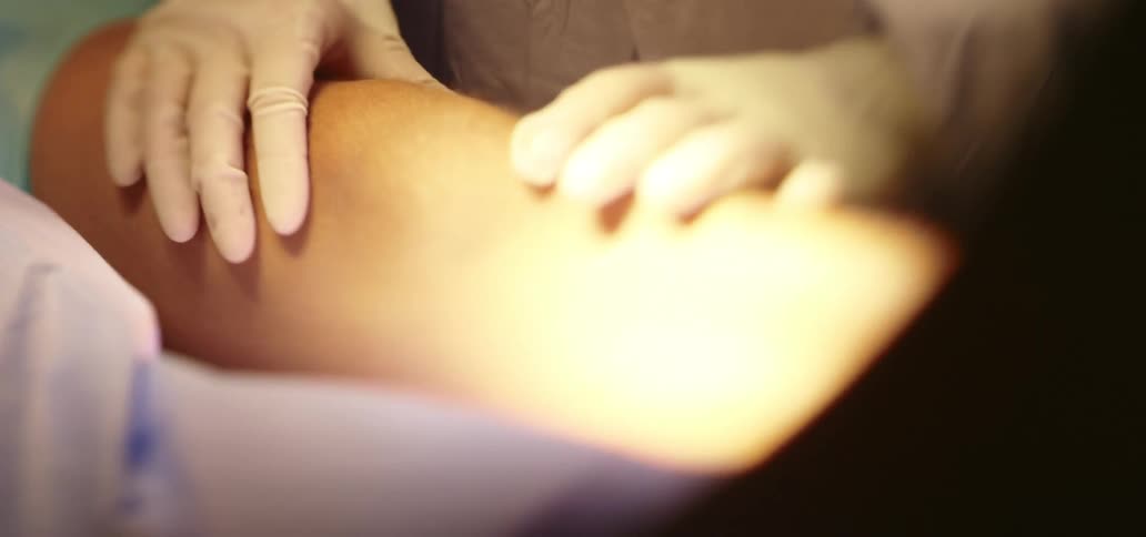 A surgeon is examining a patient