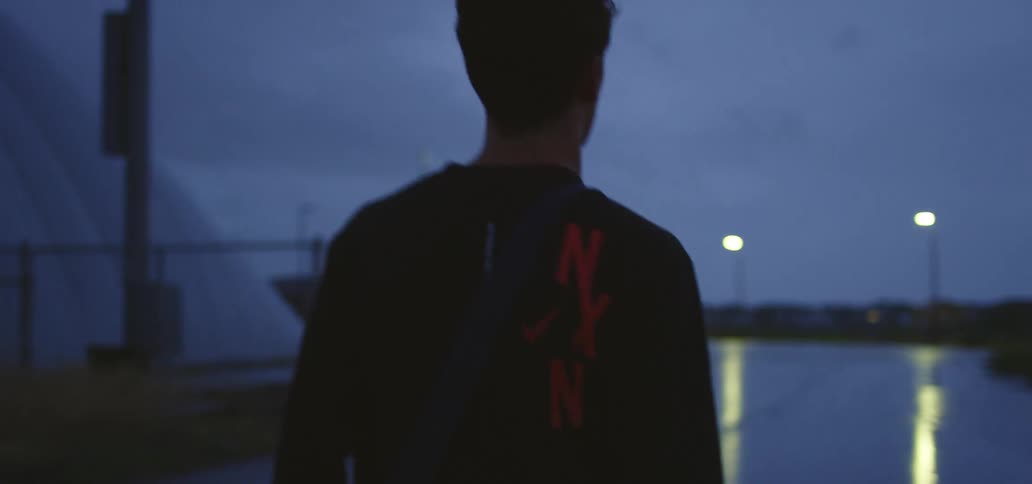 Young man holding a small trophy on his hand walks outdoors early in the morning