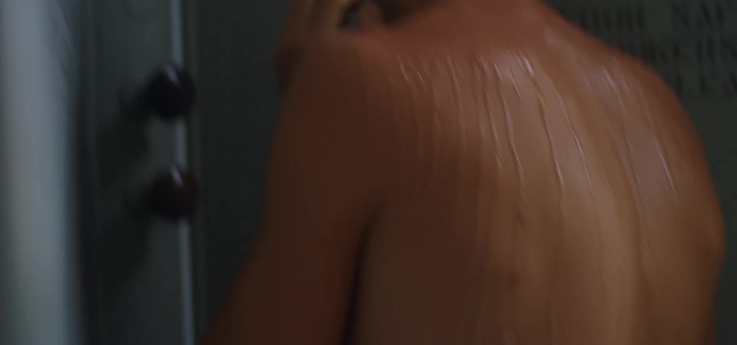 A male washes their face and hair in the shower