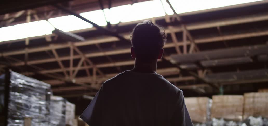 A teenager walking through a warehouse