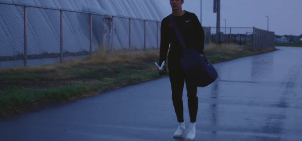 A teenager limps as he walks down a quiet street