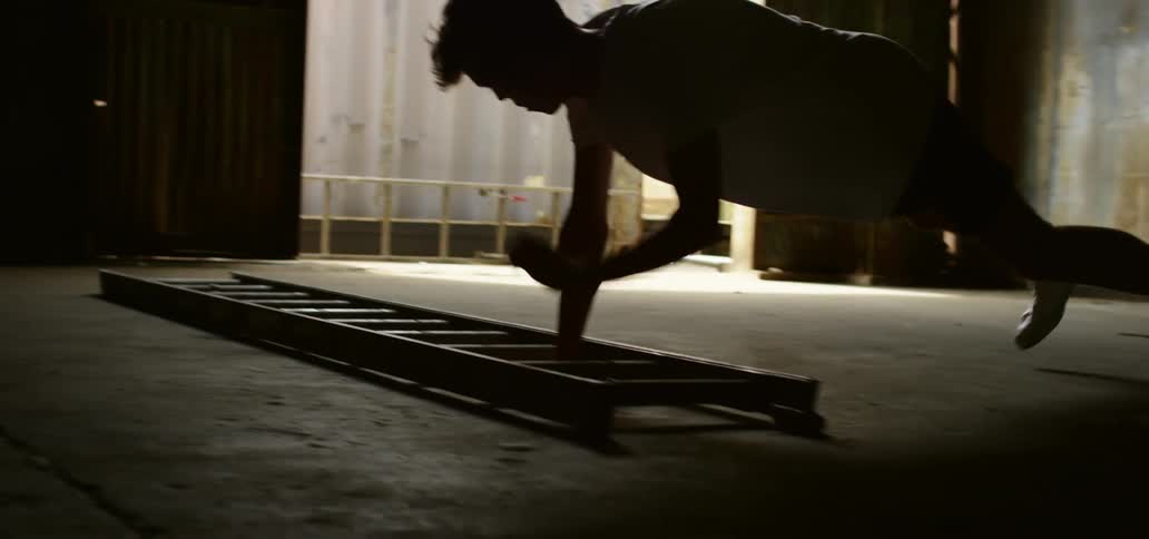 A man using a ladder on the floor to exercise
