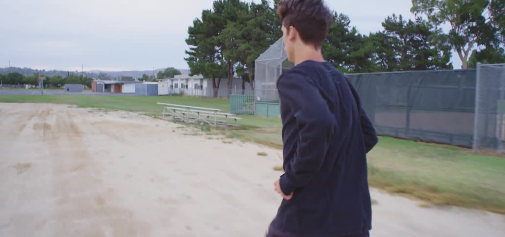 A teenage boy running outside