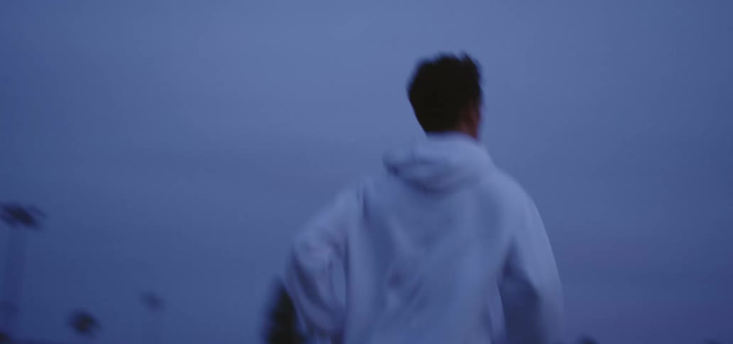 A teenager running down a neighborhood street