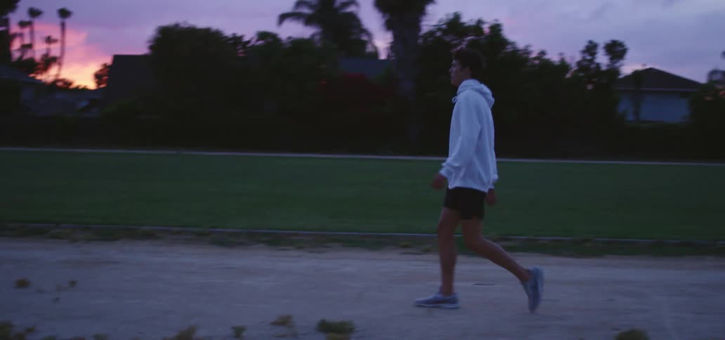 A man is walking outdoors at dusk